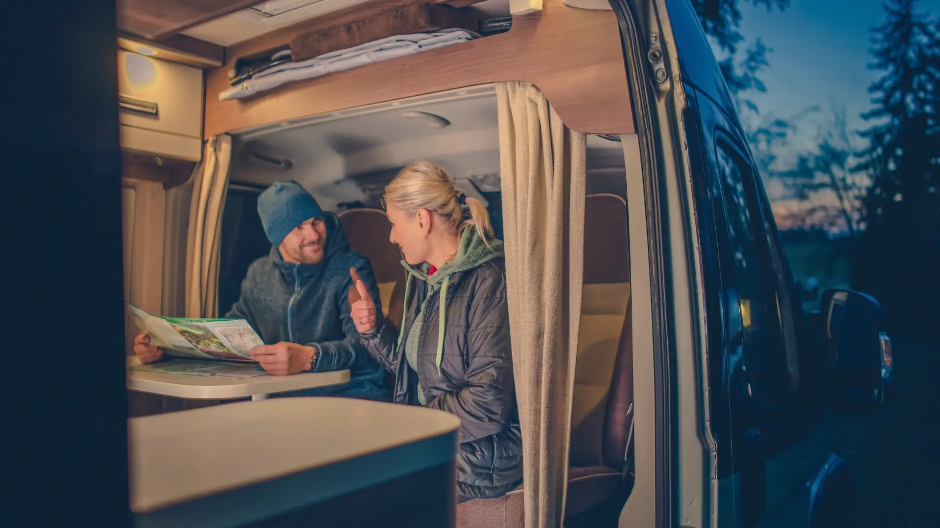 SportingNomad - Couple planning their camping adventure in a van